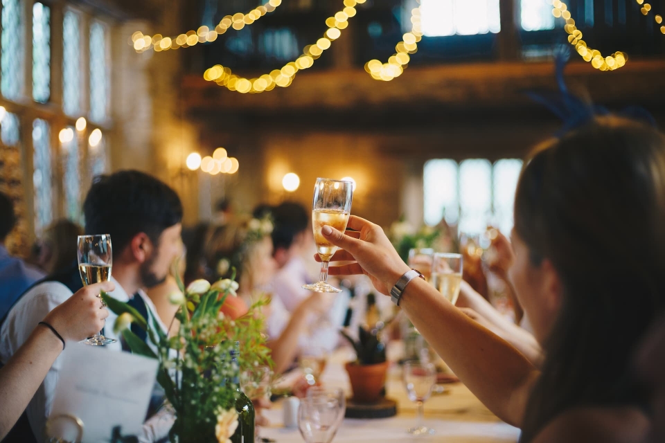 Guests raising their glasses during a toast at a wedding