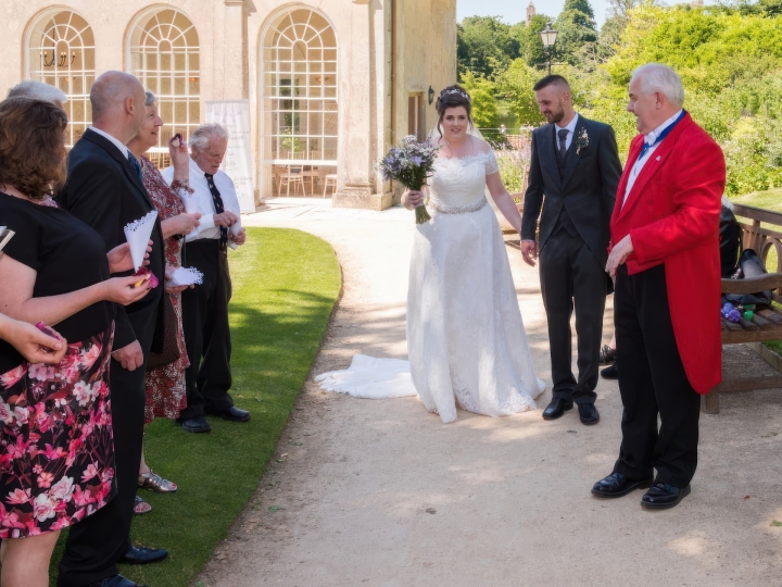 Roger leading a Bride and Groom in front of their family and friends