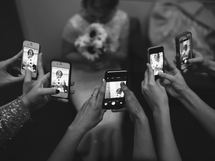 Guests taking pictures of a Bride on their mobile phones